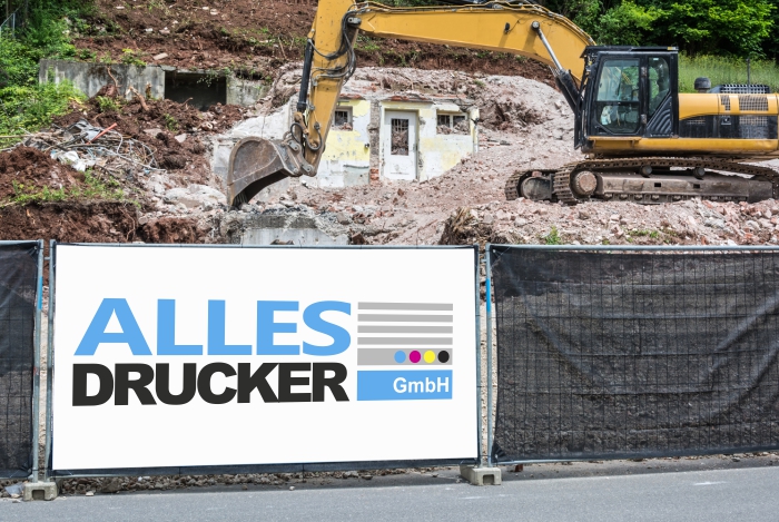 Bauzaunplane Bauzaunplane mit dem Allesdrucker Logo vor einem Bagger